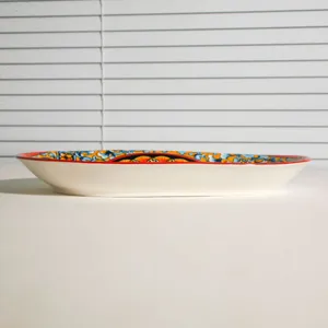 Detailed side view of a ceramic bohemian decorative plate on a white table surface.