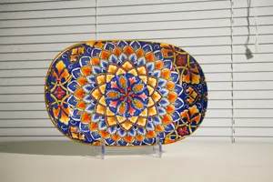 Bohemian style ceramic oval fish plate with vibrant colorful mandala patterns for dining table.
