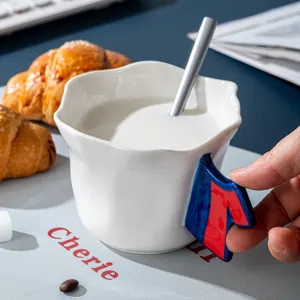 Tazza da caffè in ceramica bianca con bordo floreale e manico creativo, immagine principale.