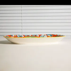 Closeup detail of the ceramic oval fish plate with vibrant bohemian style colorful patterns.