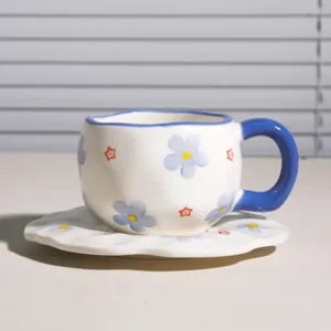 Juego de taza y plato de café de cerámica pintada a mano con asa azul y bonitos motivos florales.