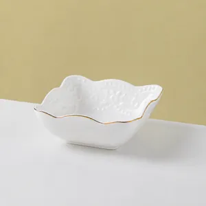 Detail view of the elegant square ceramic bowl featuring delicate embossed butterfly patterns and gold trim.