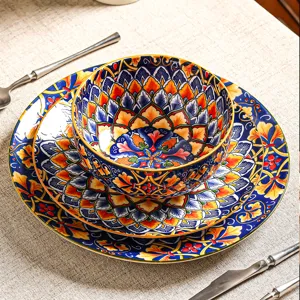 Dettaglio in primo piano del set di ciotole e piatti in ceramica boho con motivi colorati vivaci.