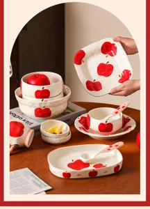 Vista dettagliata del set di stoviglie in ceramica con motivi di mele rosse per la casa.