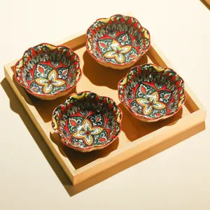 Set aus vier dekorativen Keramikschalen mit bunten Blumenmustern in einem Holztablett.