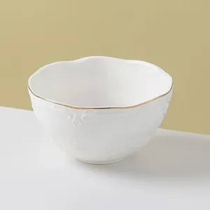 Close-up of the delicate white ceramic bowl featuring elegant gold rim and subtle embossed relief.