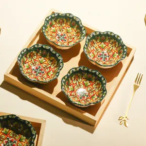 Set of four ceramic flower-shaped bowls in a wooden tray with gold fork for snacks and fruit.
