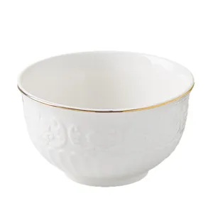 Detailed view of the white ceramic bowl featuring elegant embossed patterns and a sleek gold rim.