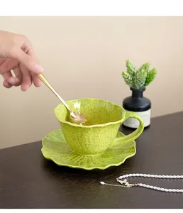 Vista detallada de la taza de café de cerámica verde con una cuchara dorada elegante.