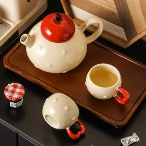 Ceramic tea set with teapot and cups, cute red lid design, perfect for home kitchen and gift.