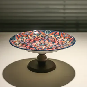 Vista di dettaglio della fruttiera in ceramica con supporto e bellissimi motivi mandala.