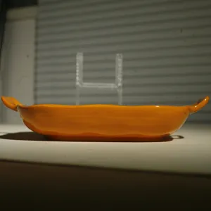 Ceramic baking dish with double handles, vibrant orange square dinner plate for kitchen food.