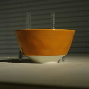 Detailansicht der orange-weißen Keramikschale mit glänzender Glasur und glatter Verarbeitung.