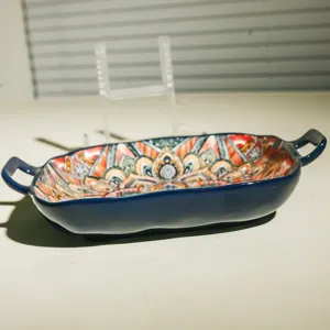 Ceramic baking dish with bohemian pattern, double handles, ideal for oven and table serving.