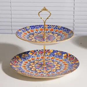 Frutero y soporte para tartas de cerámica de dos niveles con diseño bohemio y asa dorada.