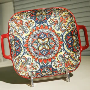 Detailed view of square ceramic baking dish with double handles and vibrant bohemian pattern.