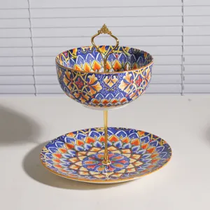 Frutero y soporte para postres de cerámica estilo bohemio con asa dorada y patrones coloridos.