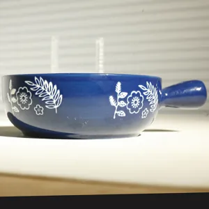Ciotola da forno in ceramica blu con manico, con graziosi motivi floreali bianchi in cucina.