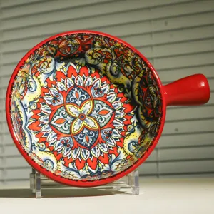 Primo piano di una vivace ciotola da forno in ceramica con manico e motivo maiolica siciliana