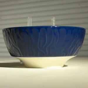 Nahaufnahme Detail einer dunkelblauen Keramikschüssel mit einzigartiger strukturierter Reliefoptik.
