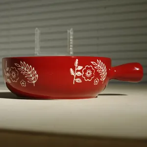 Ciotola da forno in ceramica rossa con manico e motivo floreale bianco per cucina.