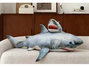 Detailed shot of large and small shark plush toy pillows displayed on a soft sofa.