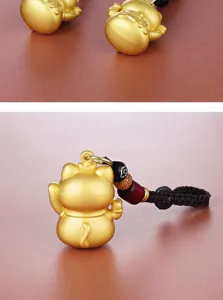 Back view of a golden lucky cat keychain with decorative beads and braided cord detail