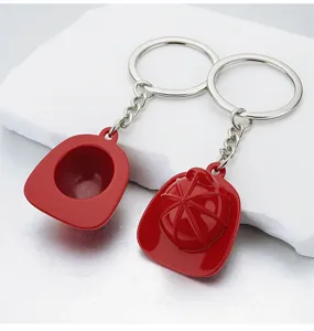 Detailed macro view of two red firefighter helmet keychains placed on white stone props