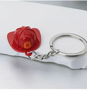 Close-up detail of a miniature red firefighter helmet keychain with flame emblem