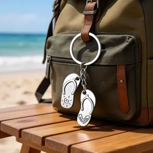 Creative silver metal flip-flops keychain hanging on a canvas backpack by the beach side