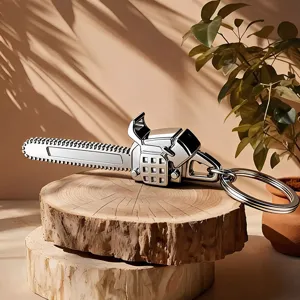Miniature silver metal chainsaw keychain accessory displayed on natural wood base