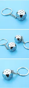 Vue macro d'un porte-clés dé en chrome massif sous plusieurs angles sur fond bleu