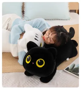 Detailed view of cute black and white cat plush toy pillow on comfortable bedding