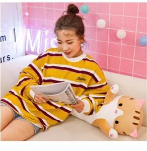 Grazioso cuscino in peluche a forma de gatto lungo in scena, morbida bambola per bambini.