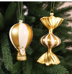Gros plan d'élégantes décorations de Noël dorées et blanches en forme de montgolfière et bonbon