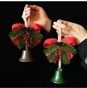 Detailed view of Christmas bell ornaments with red burlap bows and pine needles