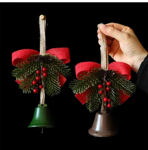 Close-up detail of festive Christmas bell hanging ornaments with pine needles and berries.