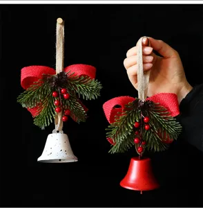 Red and white Christmas bell ornaments with pine needles and red berries detail