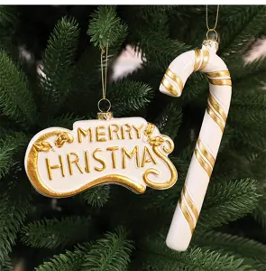 Gros plan d'ornements de sapin de Noël blanc et or avec des vœux de fête
