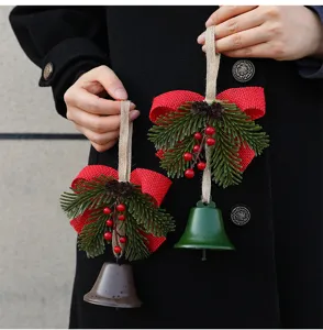 Detailed view of Christmas bell ornaments with red burlap bows and festive pine decorations