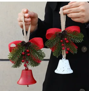 Close-up of rustic Christmas bell ornaments with red burlap bows and pine needles