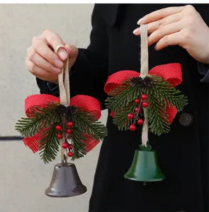 Close-up of rustic Christmas bell ornaments with red burlap bow and green pine needles