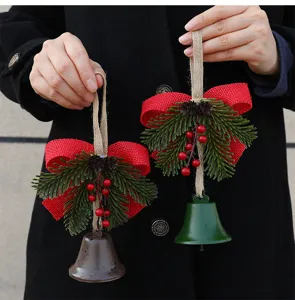 Close-up of Christmas bell ornaments with pine needles and red burlap bows