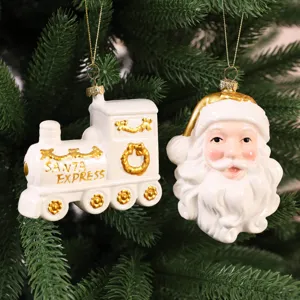 Décorations de Noël en céramique blanche, père Noël et train, sur un sapin vert