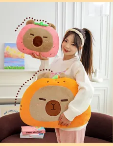 Dettaglio cuscino peluche capibara con morbidi design fragola e arancia per decorazione casa.