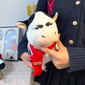 Nahaufnahme des lustigen Plüschkuh-Spielzeugs mit humorvollem Gesichtsausdruck und Schal.
