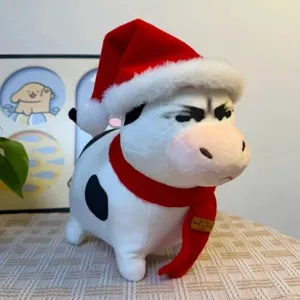 Süßes lustiges Kuh Plüschtier Detailansicht, weiches Kuscheltier mit roter Weihnachtsmütze.