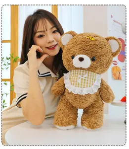 Detailed close-up view of the adorable brown plush teddy bear toy featuring a sweet plaid bib