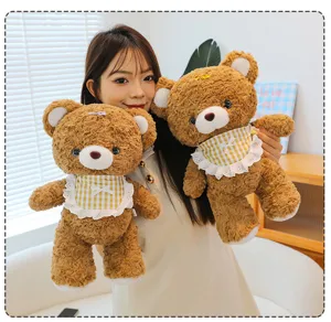 Cute brown mocha teddy bear plush toy detail showing soft fabric and lovely plaid bib design.