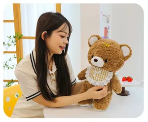Cute brown plush teddy bear toy with plaid bib and hairclip, soft stuffed doll for girls.